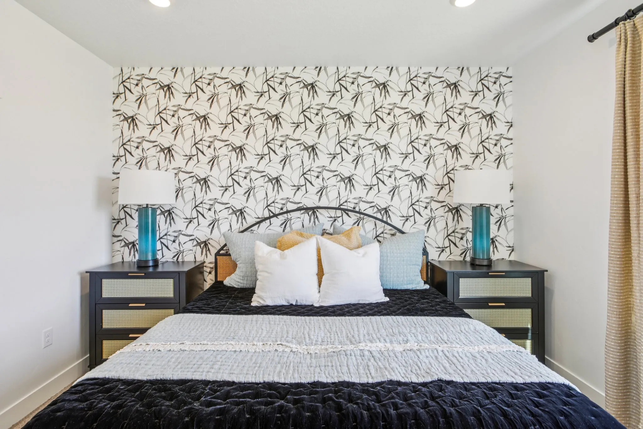 Recessed lighting illuminates the space, featuring a decorative accent wall and contrasting white walls
