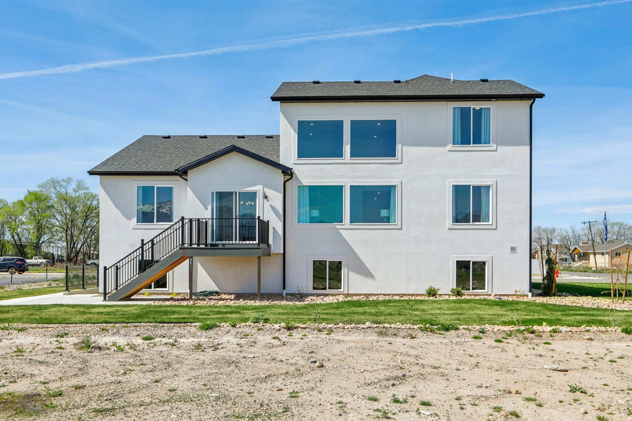 Multi-level stucco exterior with a dark shingle roof