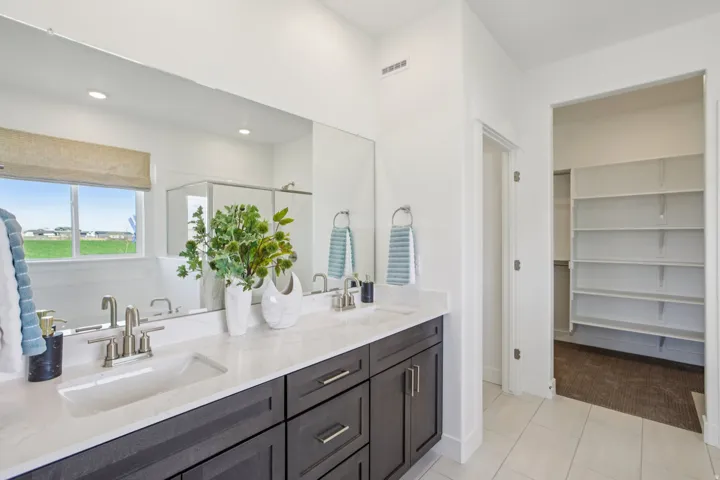 Dual vanity with undermount sinks, stone-finish countertop, and brushed nickel fixtures