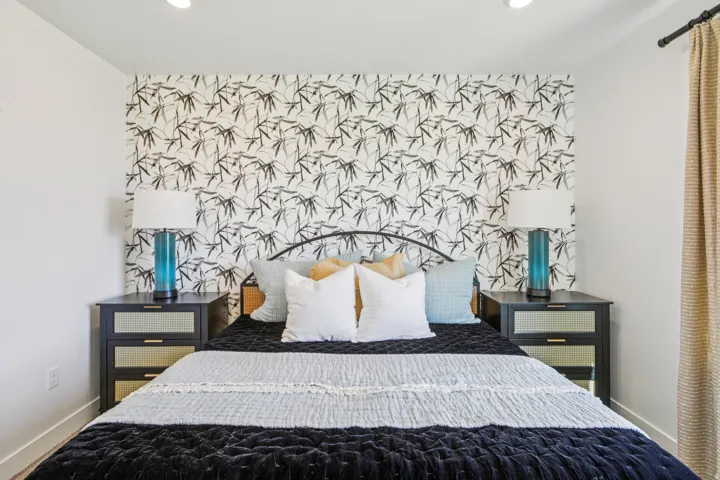 Recessed lighting illuminates the space, featuring a decorative accent wall and contrasting white walls