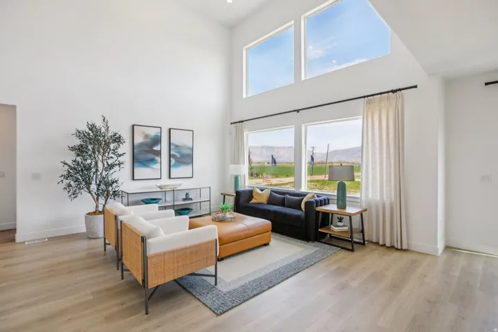 High ceilings, abundant natural light, wood-finish flooring, white walls, and large windows