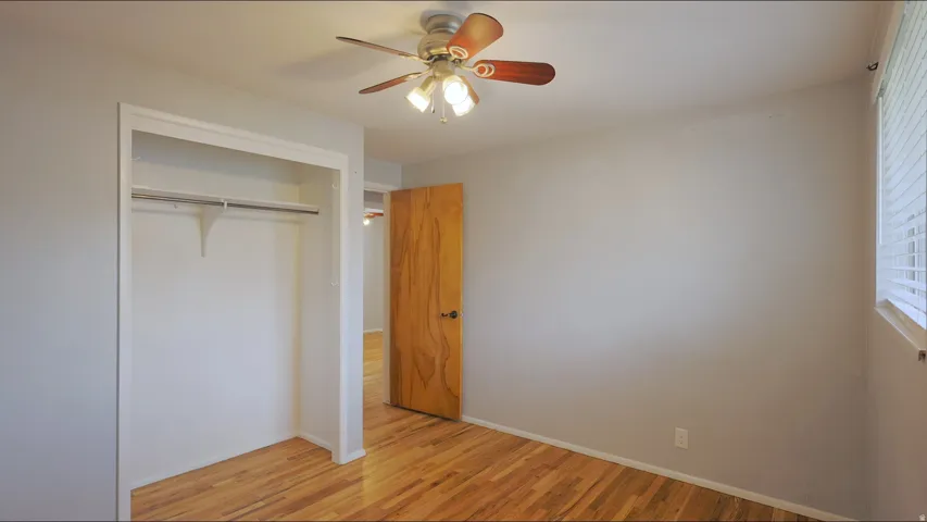Hardwood flooring, ceiling fan, and window with horizontal blinds