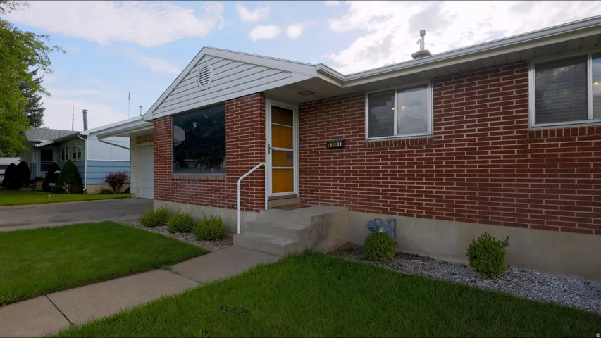 Brick exterior with white siding accents and a pitched roofline