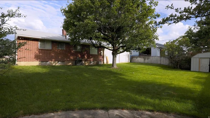Expansive lawn with mature trees and a privacy fence