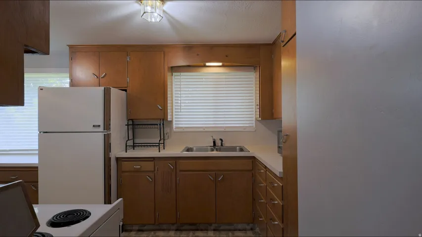 Kitchen featuring wood cabinetry, white countertops, and a double basin sink