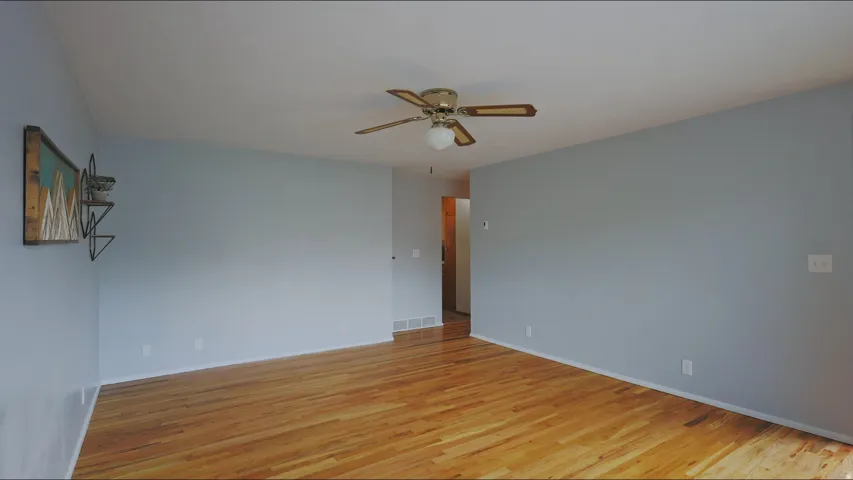 Hardwood flooring, painted walls, and ceiling fan