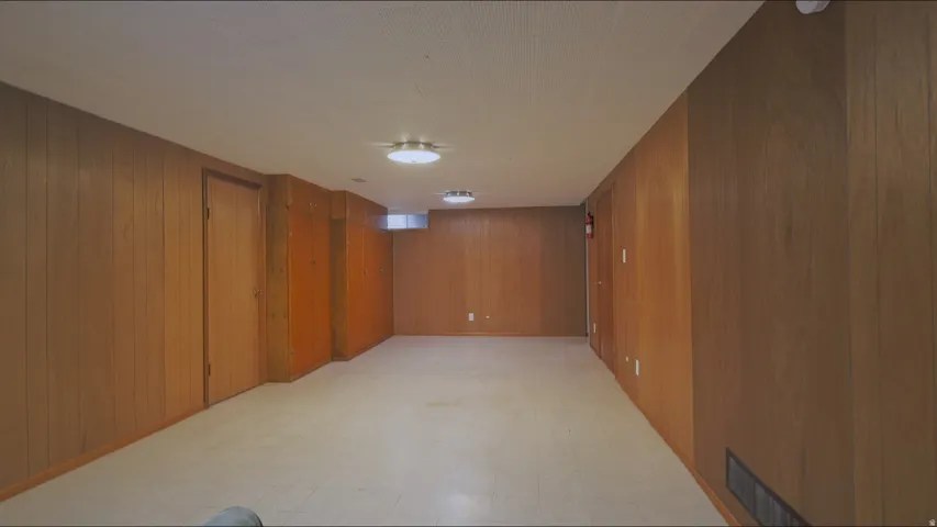 Recessed lighting, wood paneling, multiple doors, and a window