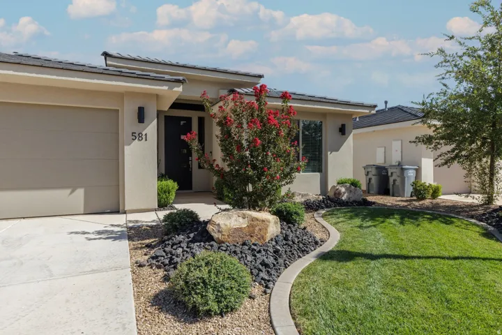 Stucco exterior with a dark entry door, an attached garage, and a concrete driveway