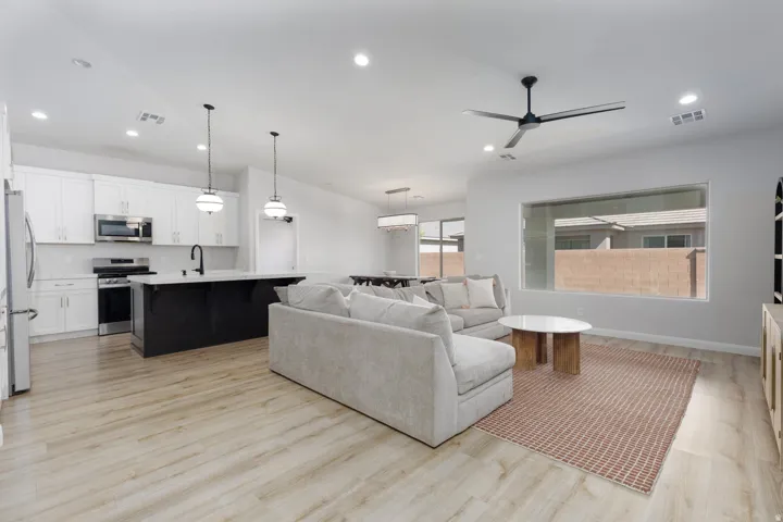 Open concept living space with wood-finish flooring, recessed lighting, and a modern ceiling fan