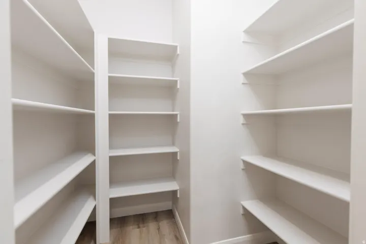 Built-in shelving with adjustable white shelves and wood-finish flooring