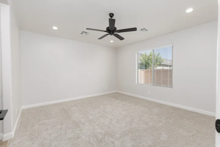 Recessed ceiling lighting, ceiling fan, carpet flooring, window with blinds, and light neutral wall finishes