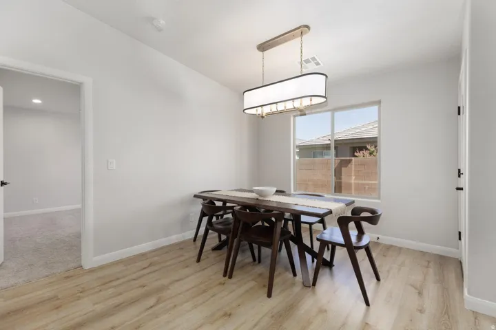 Wood-finish flooring, recessed lighting, and a contemporary chandelier