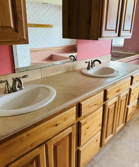 Dual basin vanity with wood-finish cabinetry and neutral countertops