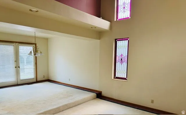 Expansive room featuring a tiered floor, recessed lighting, and a decorative chandelier