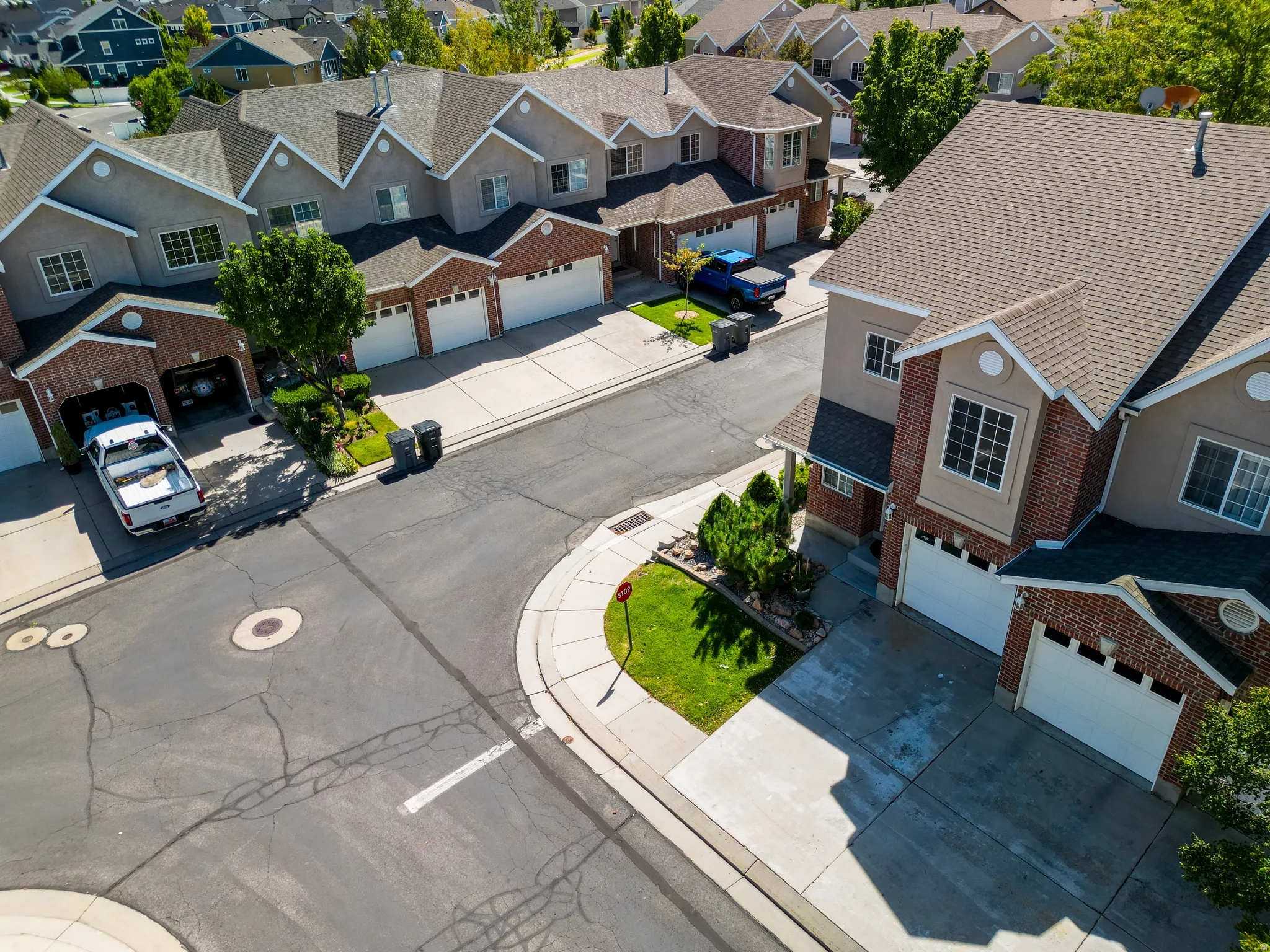 Multi-level residences featuring brick and stucco exteriors, attached garages, and pitched shingle roofs