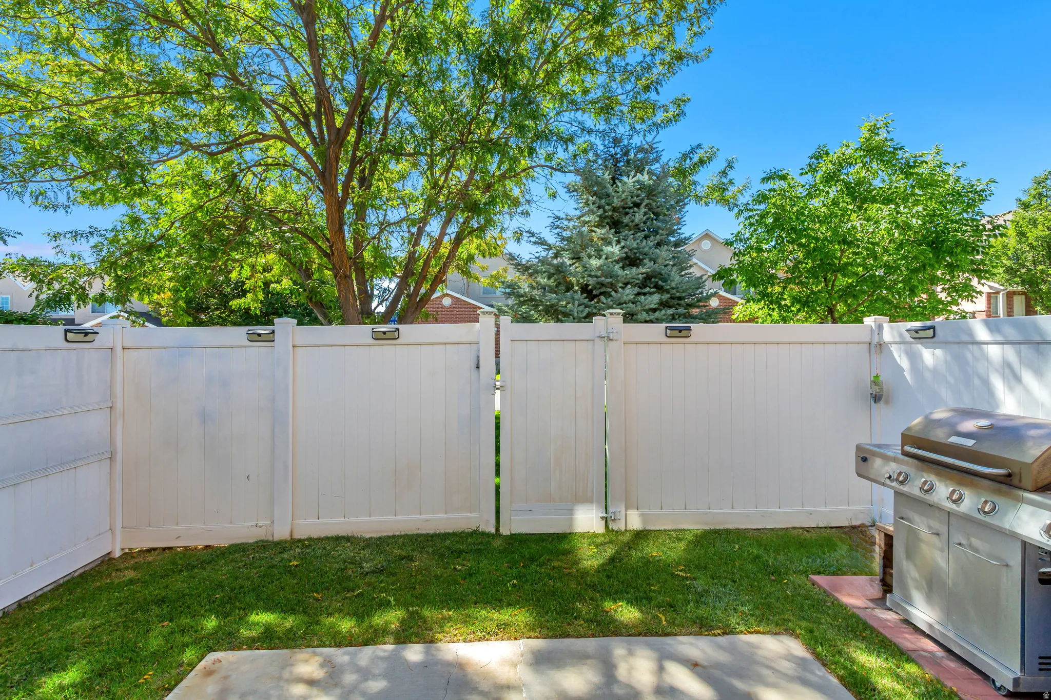 Fenced yard featuring a concrete patio and a lawn area