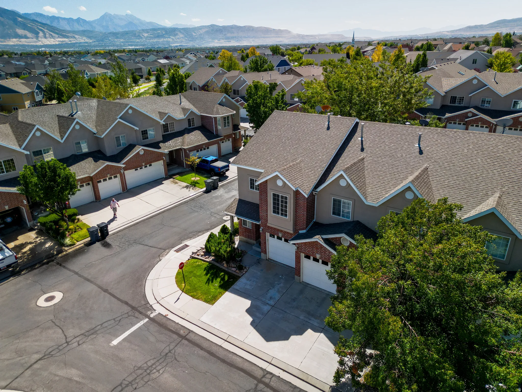 Townhome community with mountain scenery, brick and siding facades, and attached garages
