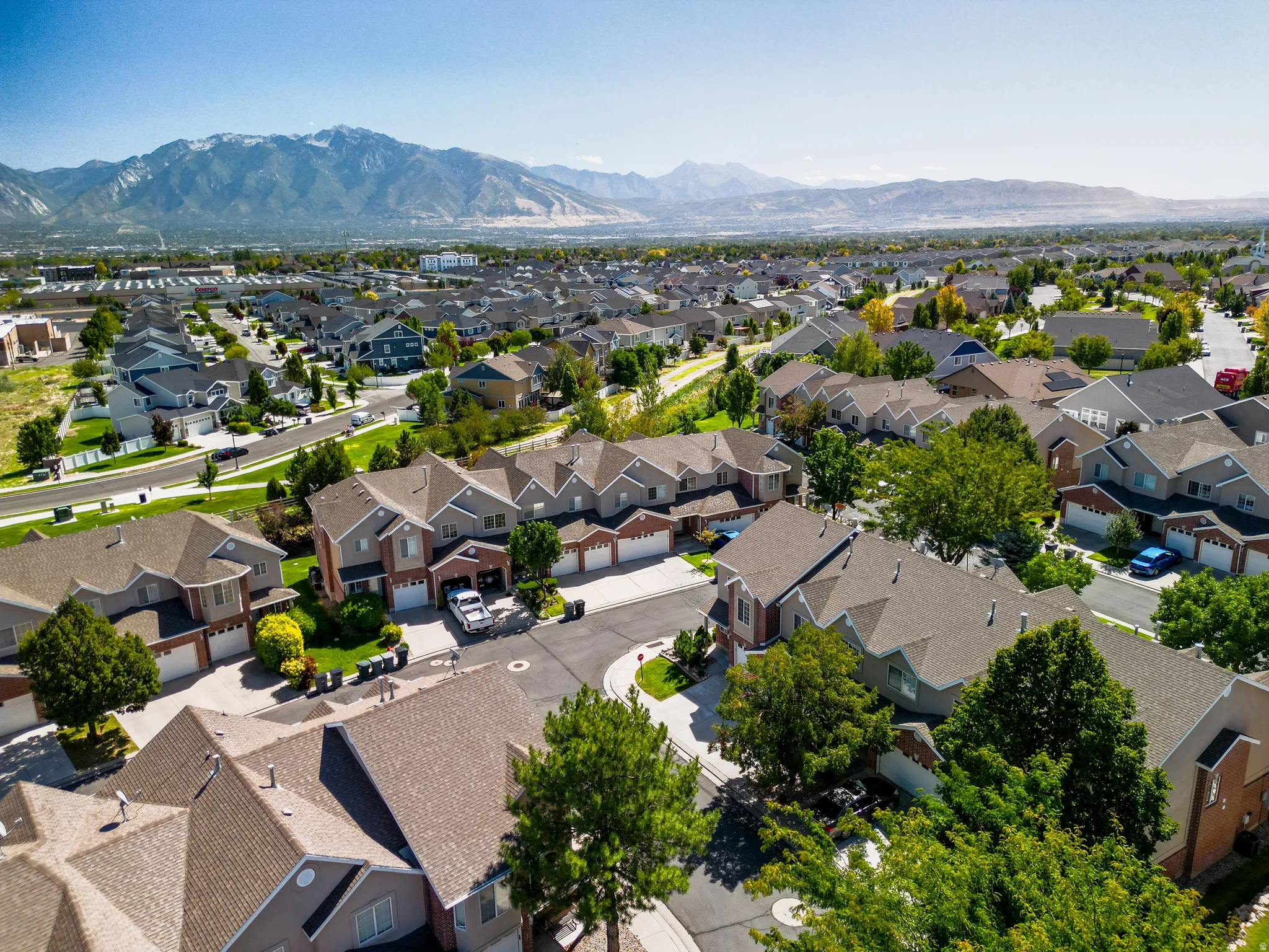 Neighborhood setting with residential homes featuring varied rooflines and a mountainous backdrop