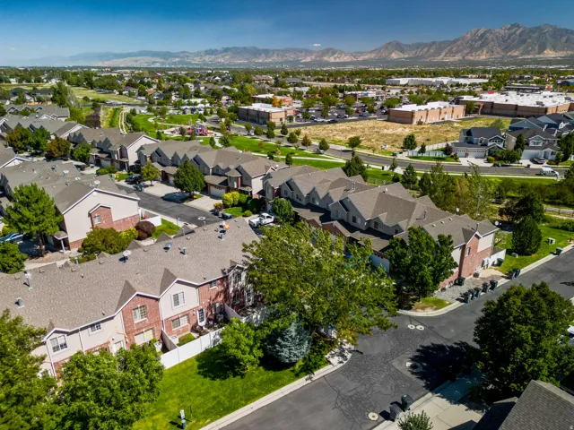 Residential community with multiple two-story structures, mature landscaping, and paved roadways
