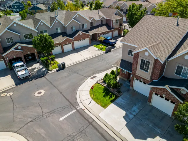 Multi-level residences featuring brick and stucco exteriors, attached garages, and pitched shingle roofs