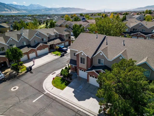 Townhome community with mountain scenery, brick and siding facades, and attached garages