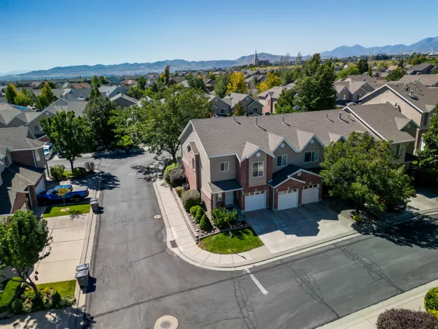 Multi-level residence featuring a brick and stucco exterior, attached two-car garage, and established landscaping