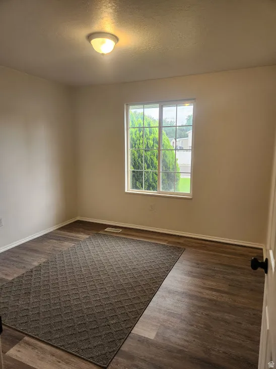 Wood-finish flooring, white trim, and a flush mount ceiling light