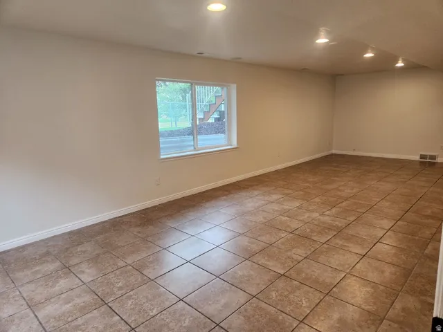 Expansive room featuring recessed lighting, a large window, tiled flooring, and light-toned walls