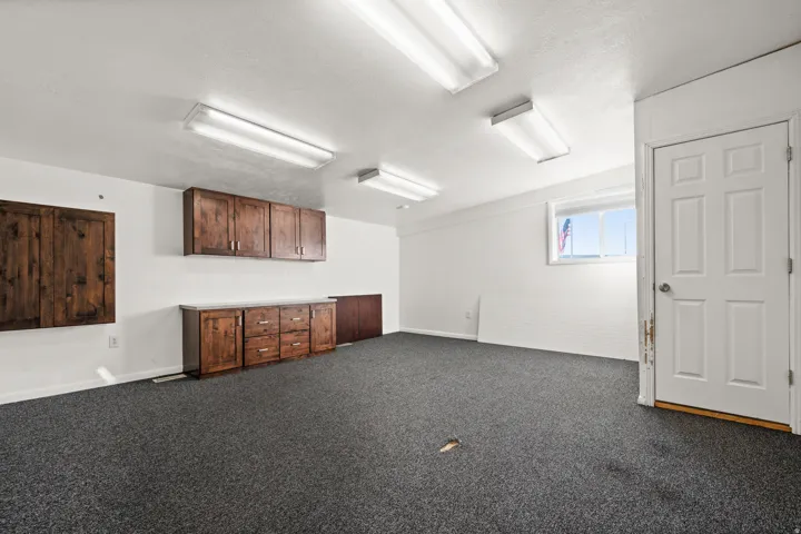 Recessed fluorescent lighting, dark wood-finish cabinetry, and a window with natural light
