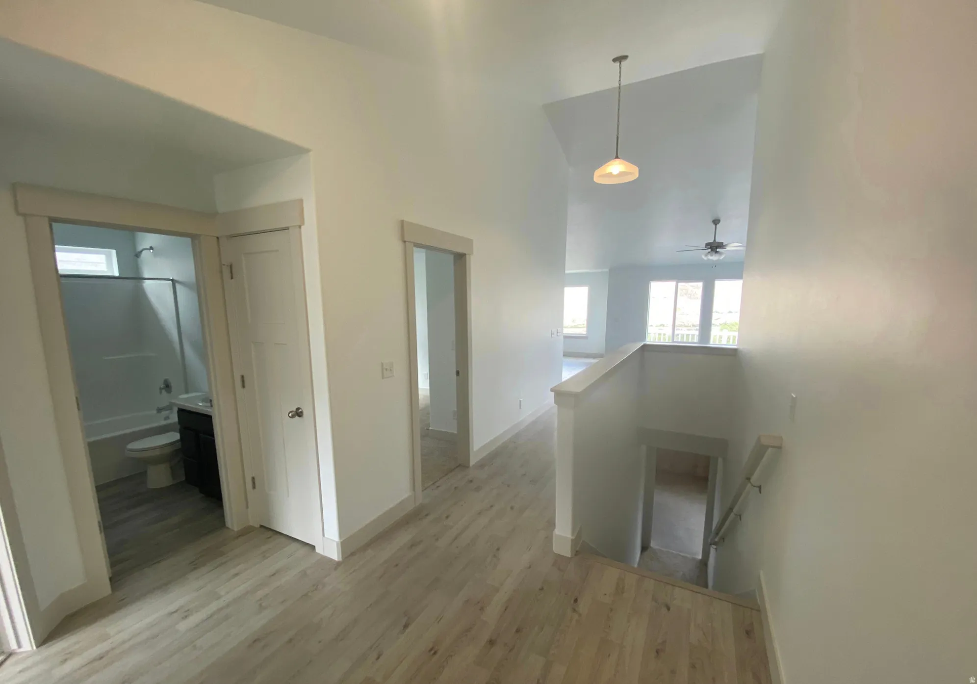 Wood-finish flooring throughout, vaulted ceiling, and recessed lighting