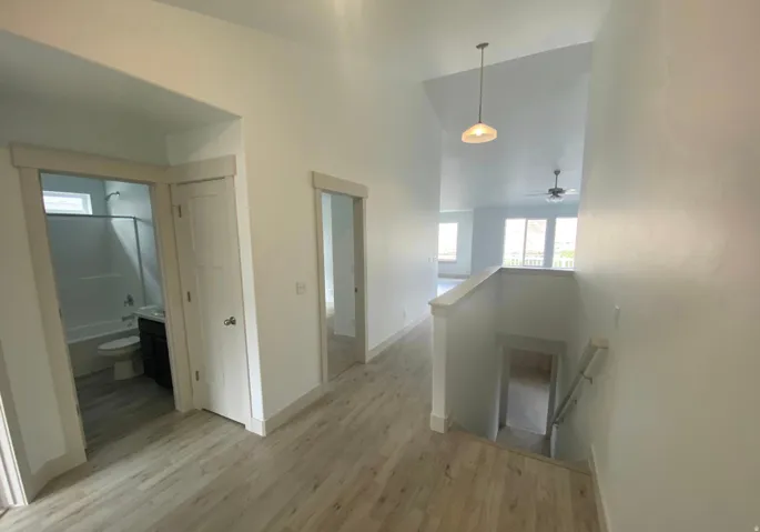 Wood-finish flooring throughout, vaulted ceiling, and recessed lighting
