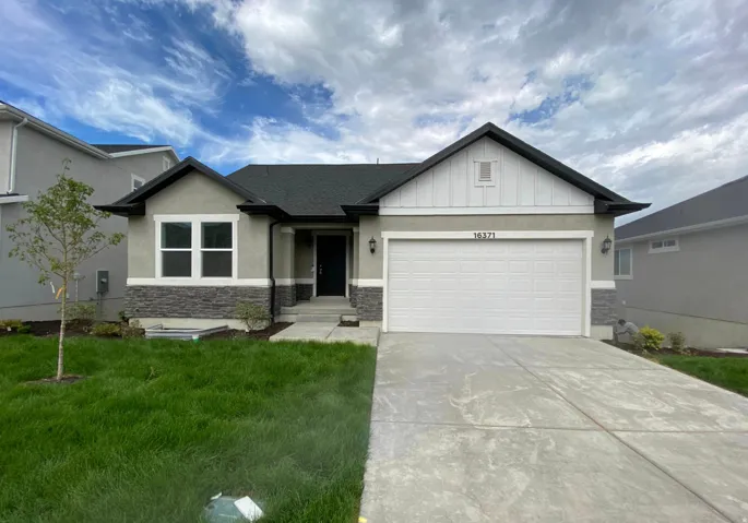 Contemporary exterior featuring stucco and stone accents, a dark shingle roof, white garage door, and a concrete driveway