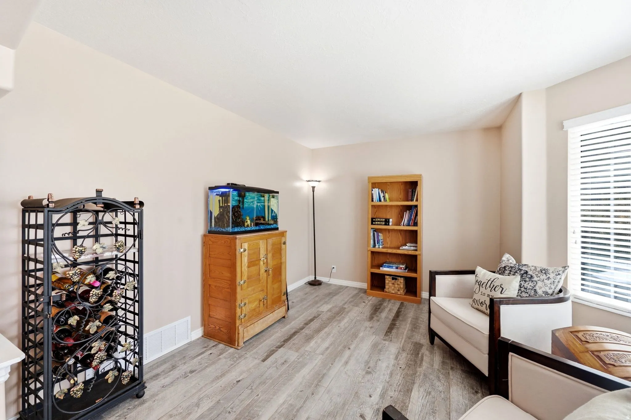 Wood-finish flooring with neutral wall tones and a window with blinds