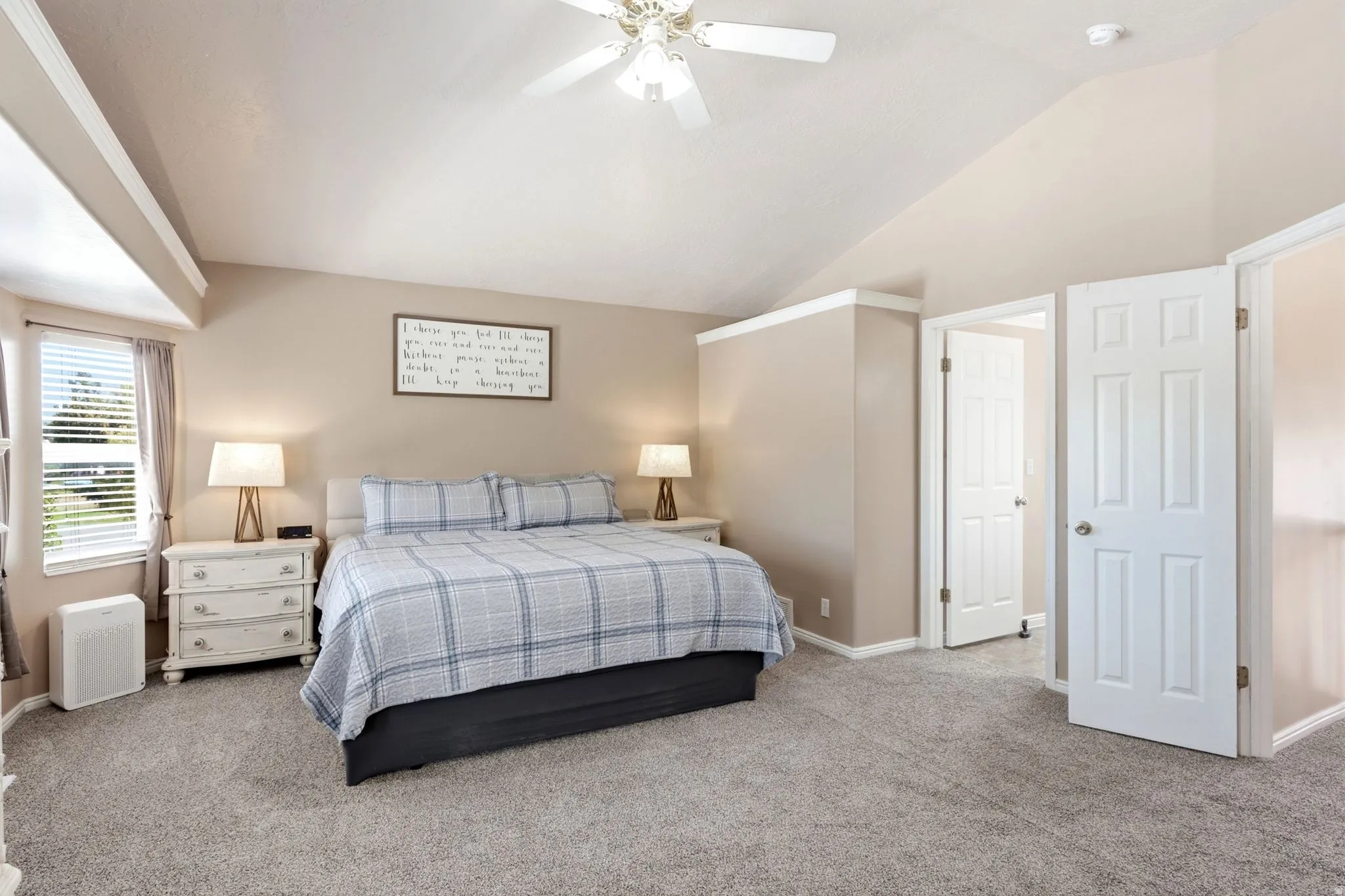 Vaulted ceiling, ceiling fan with integrated lighting, carpeted flooring, window with blinds, and paneled interior doors