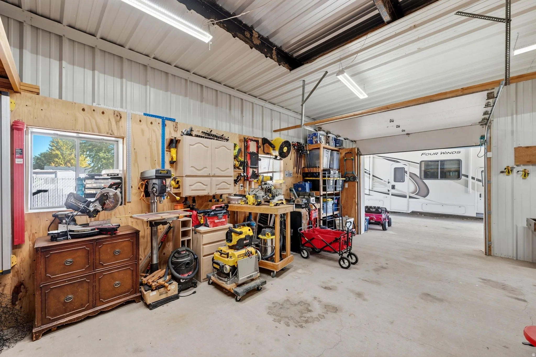 Spacious workshop featuring concrete flooring and a large garage door