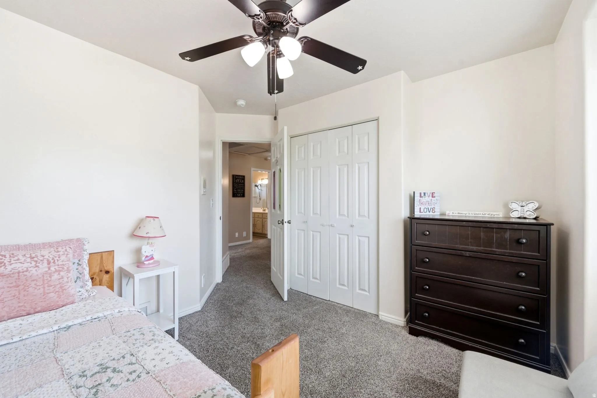 Plush carpeting, a ceiling fan with integrated lighting, and a bi-fold closet door