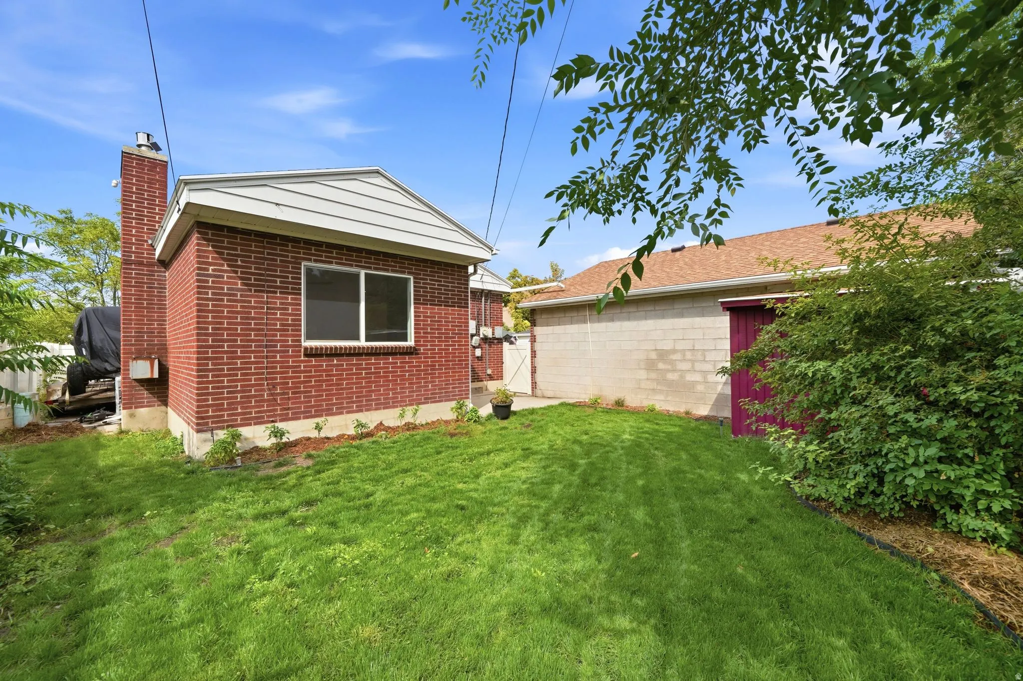 Expansive green lawn with mature landscaping, featuring a brick exterior.