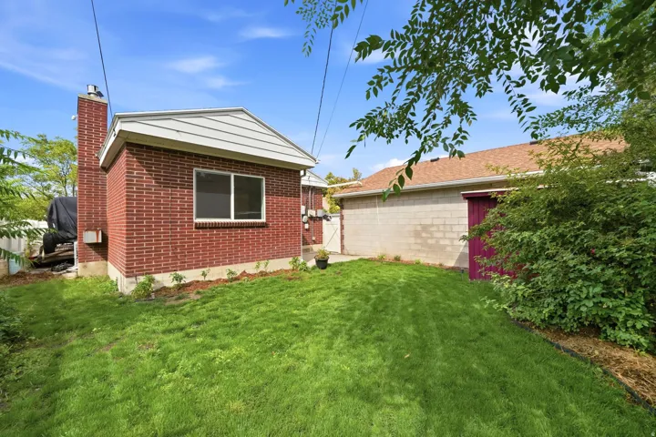Expansive green lawn with mature landscaping, featuring a brick exterior.