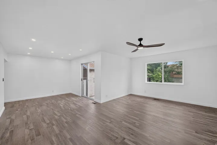 Wood-finish flooring, recessed lighting, ceiling fan, and sliding glass door