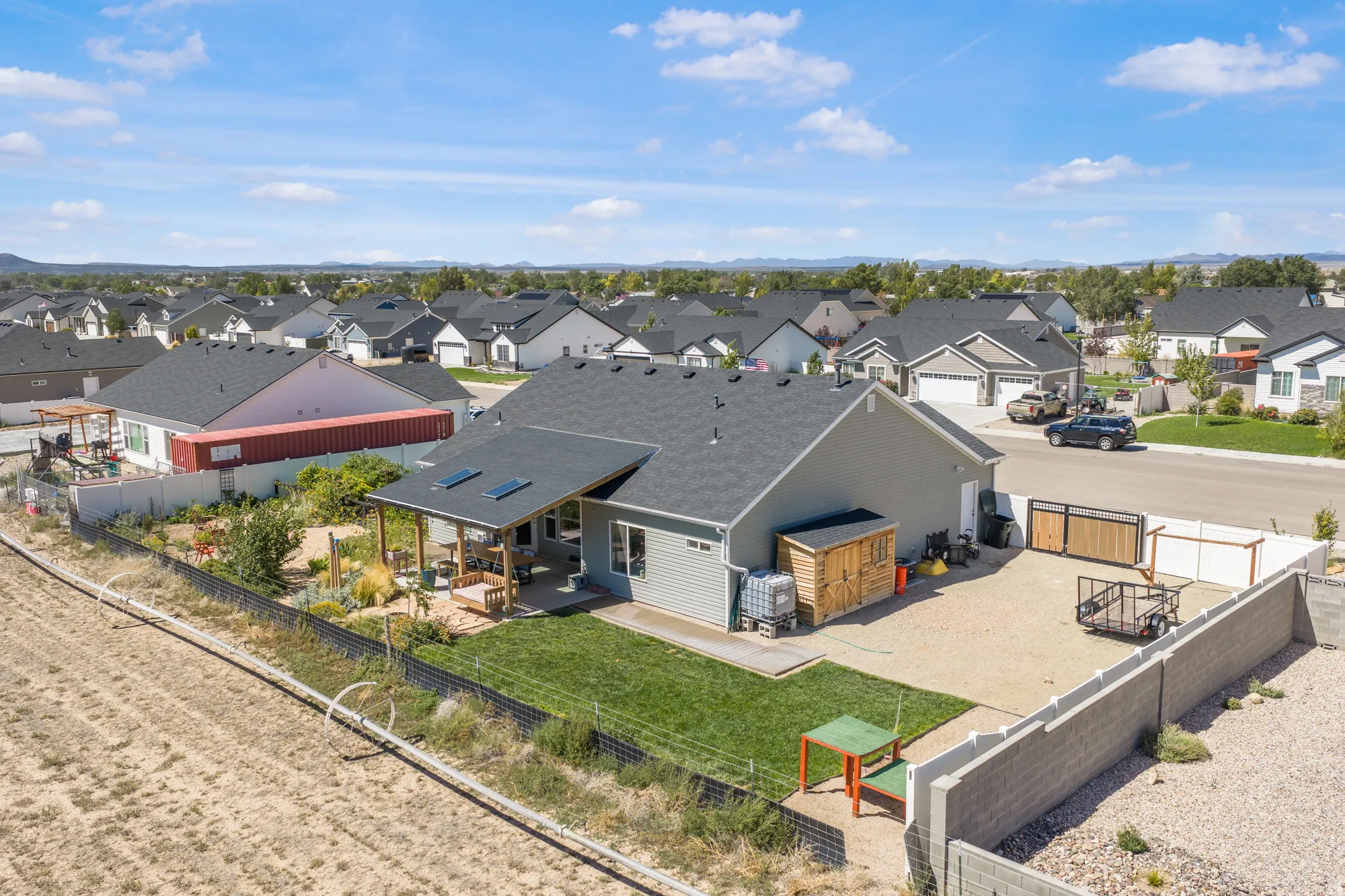 Rear exterior featuring a covered patio, solar panels, a storage shed, a gravel area, and a block wall