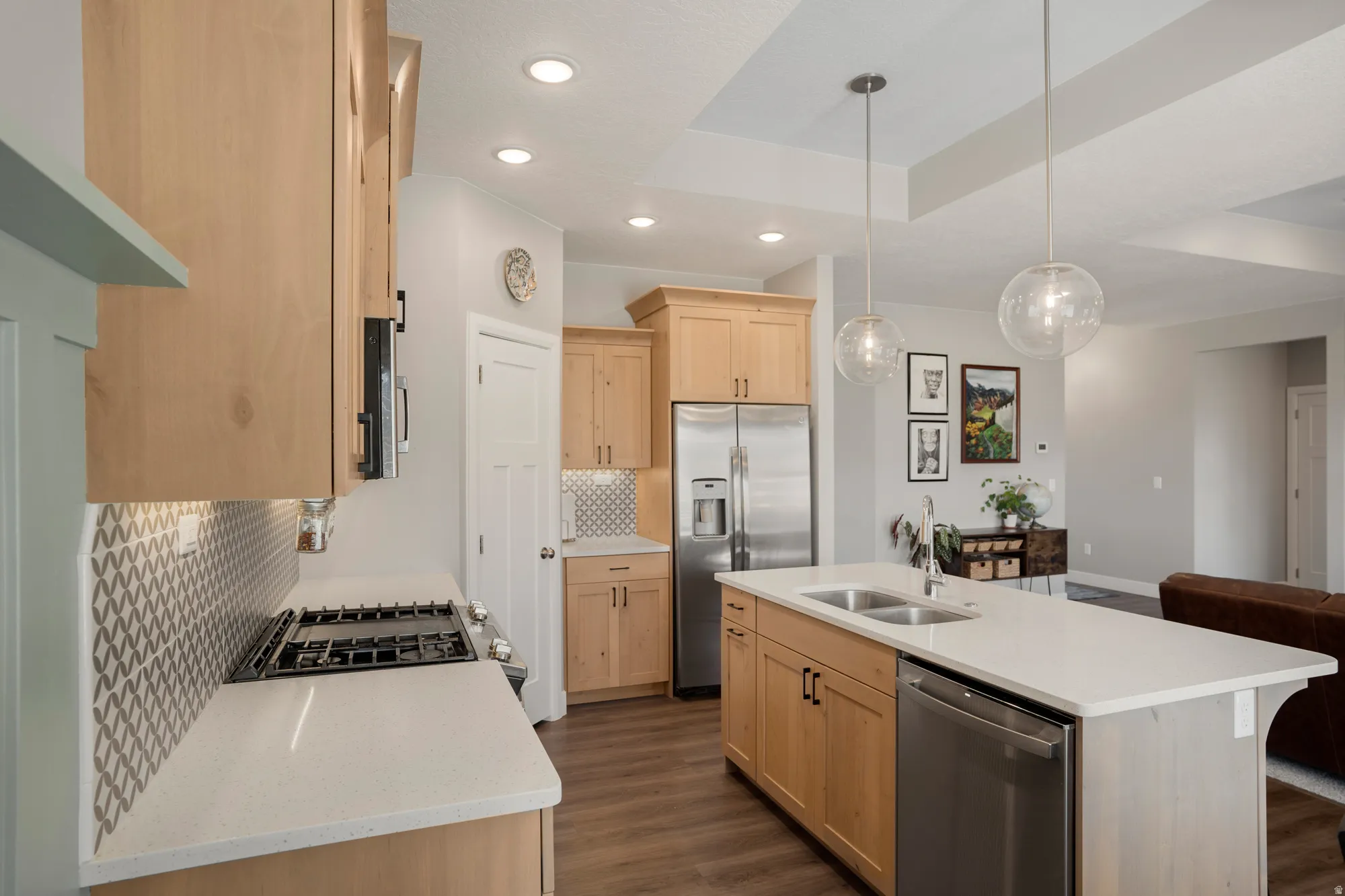 Kitchen featuring wood-finish cabinetry, stainless steel appliances, quartz countertops, and a patterned tile backsplash