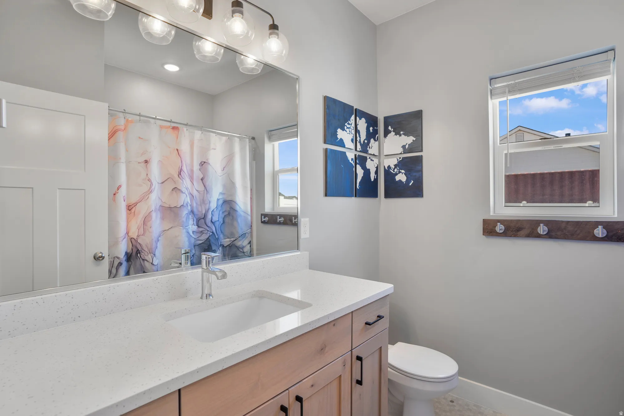 Single vanity with a light wood-finish cabinet and white countertop