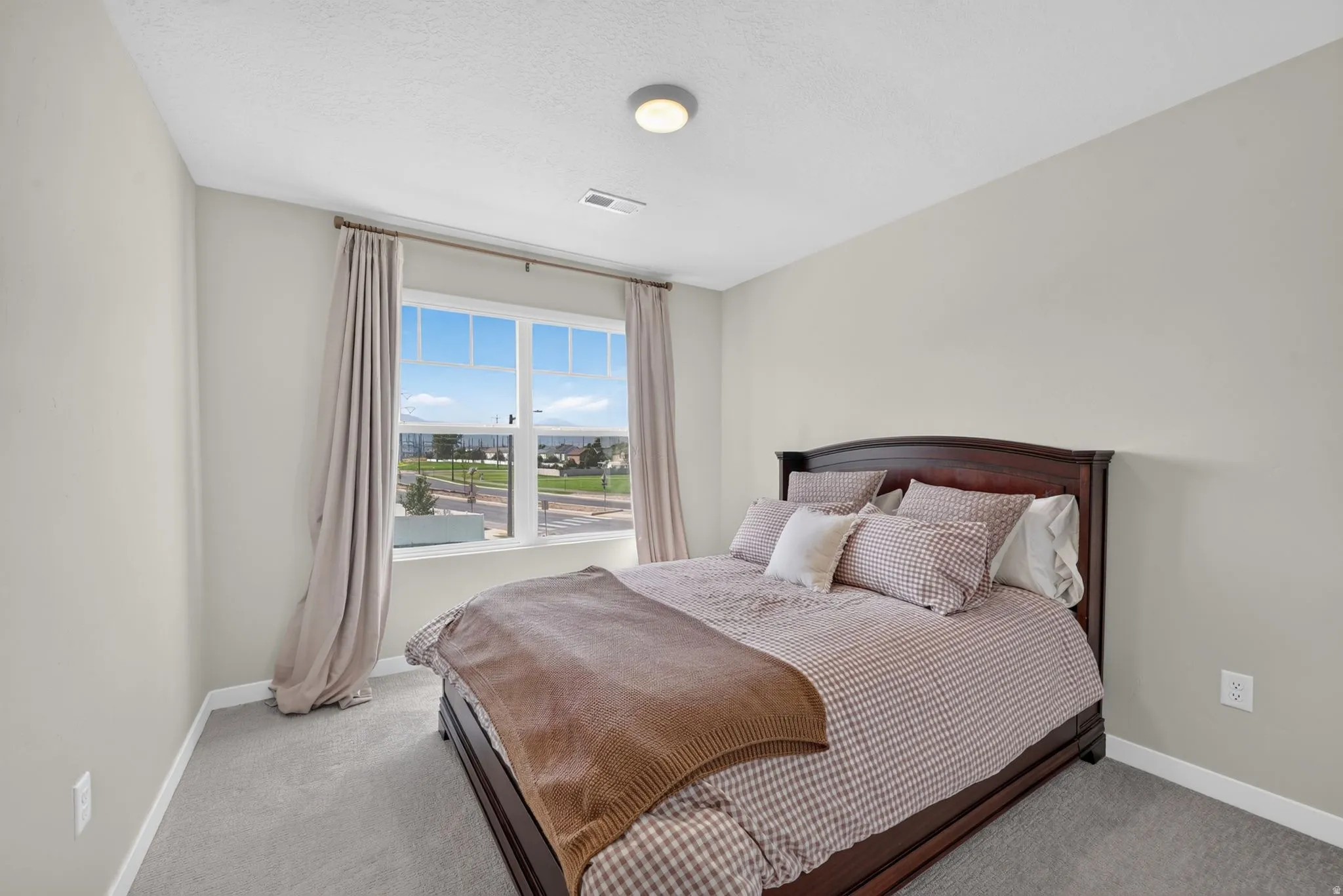 Carpeted flooring, neutral wall tones, and a large window with white trim