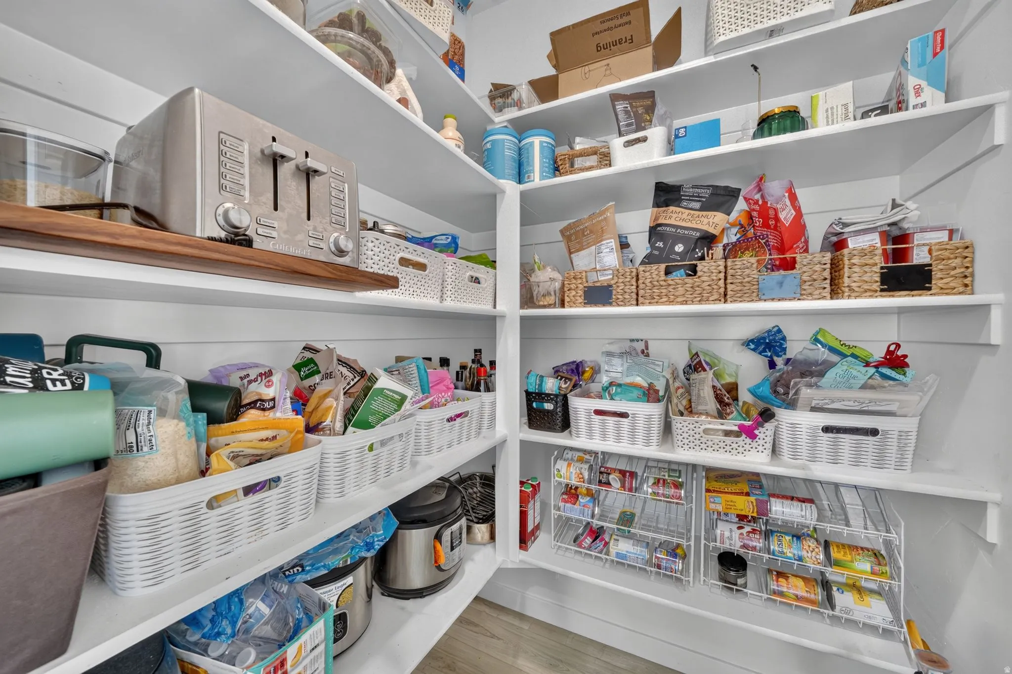 Custom built-in shelving with varied depths and a wood-finish accent shelf
