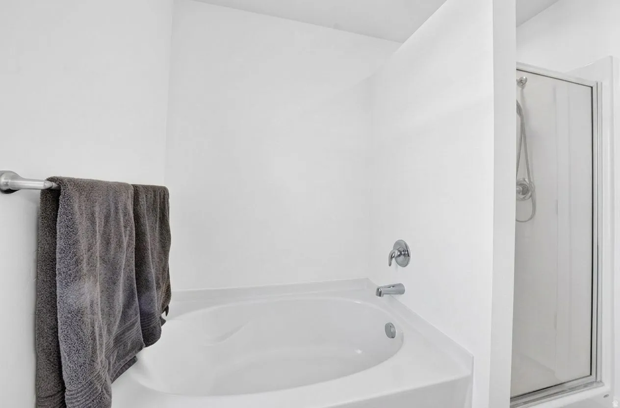 Built-in soaking tub with polished chrome fixtures and an adjacent glass-enclosed shower