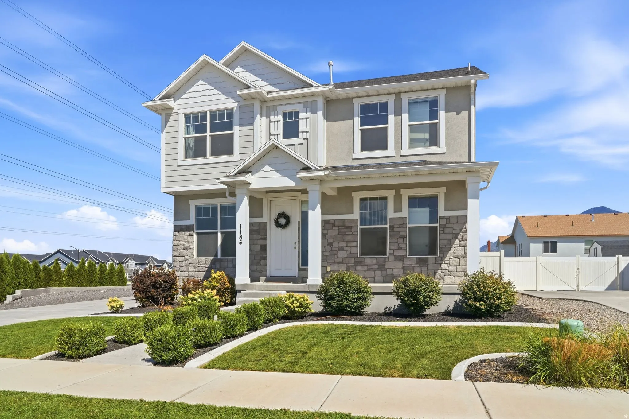 Two-story stucco and stone-faced exterior with white trim