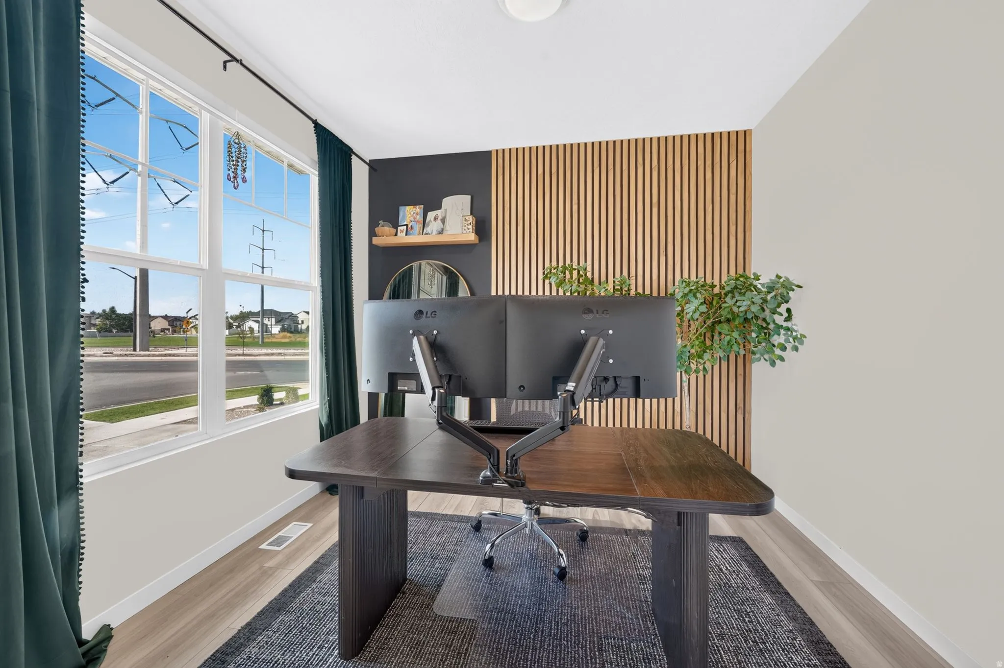 Expansive window, light wood-finish flooring, accent wall with vertical wood paneling, recessed lighting, and wall-mounted shelving
