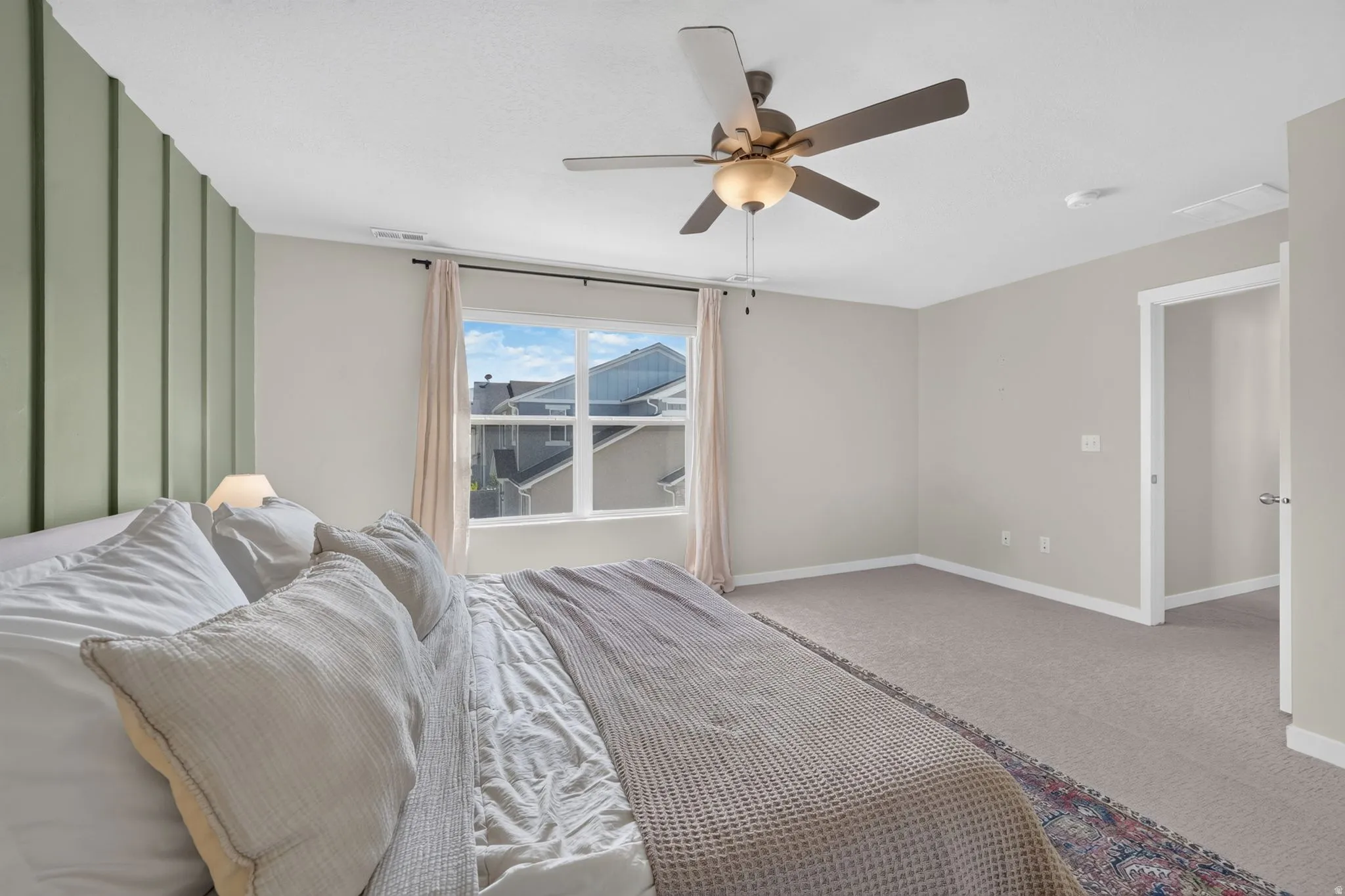 Wall panel accent, ceiling fan, carpeted flooring, and a window with blinds