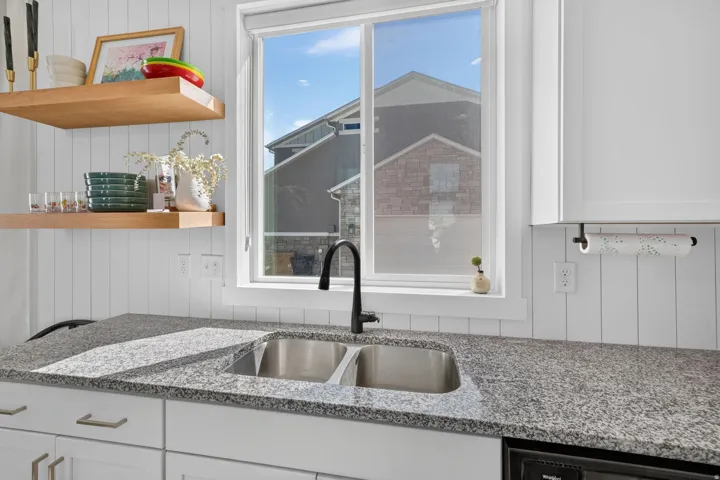 Stainless steel double basin sink with a matte black gooseneck faucet