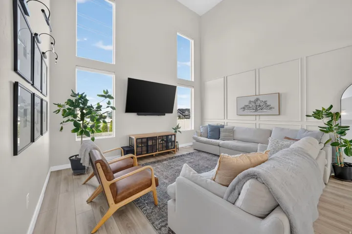 Vaulted ceilings with abundant natural light, wood-finish flooring, and decorative wall paneling